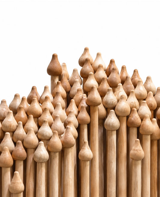 A dense arrangement of natural wood flagpoles with rounded, bulb-shaped wooden ornaments, photographed against a solid white background.