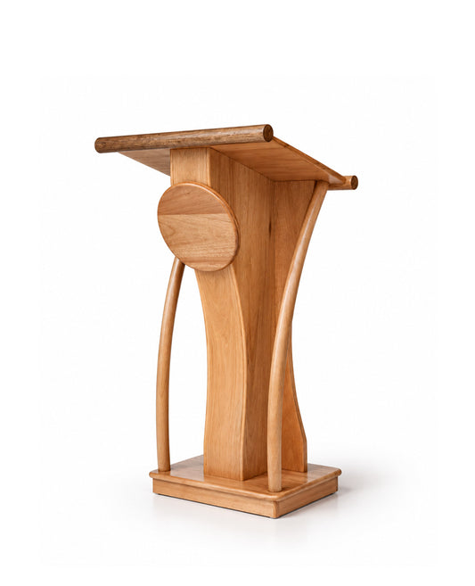 A light natural wood podium with a minimalist sculptural design, featuring curved legs and a circular detail on the front, set against a plain white background.