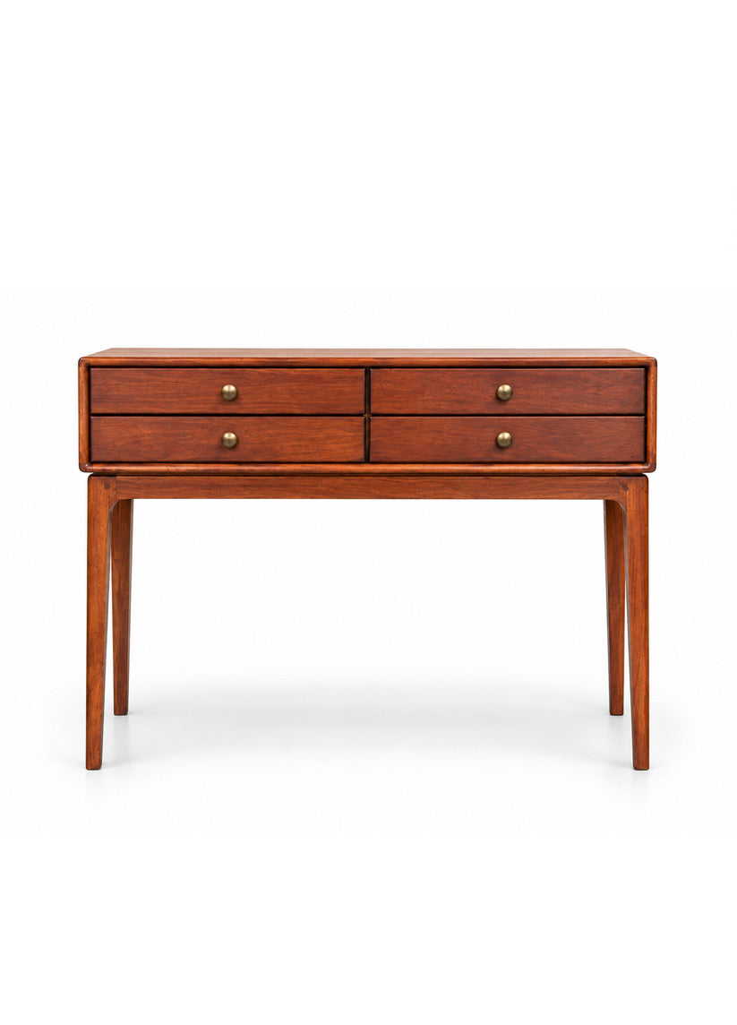 A mid-century modern wooden console table with four drawers, featuring a warm reddish-brown wood finish and small brass drawer pulls, set against a plain white background.