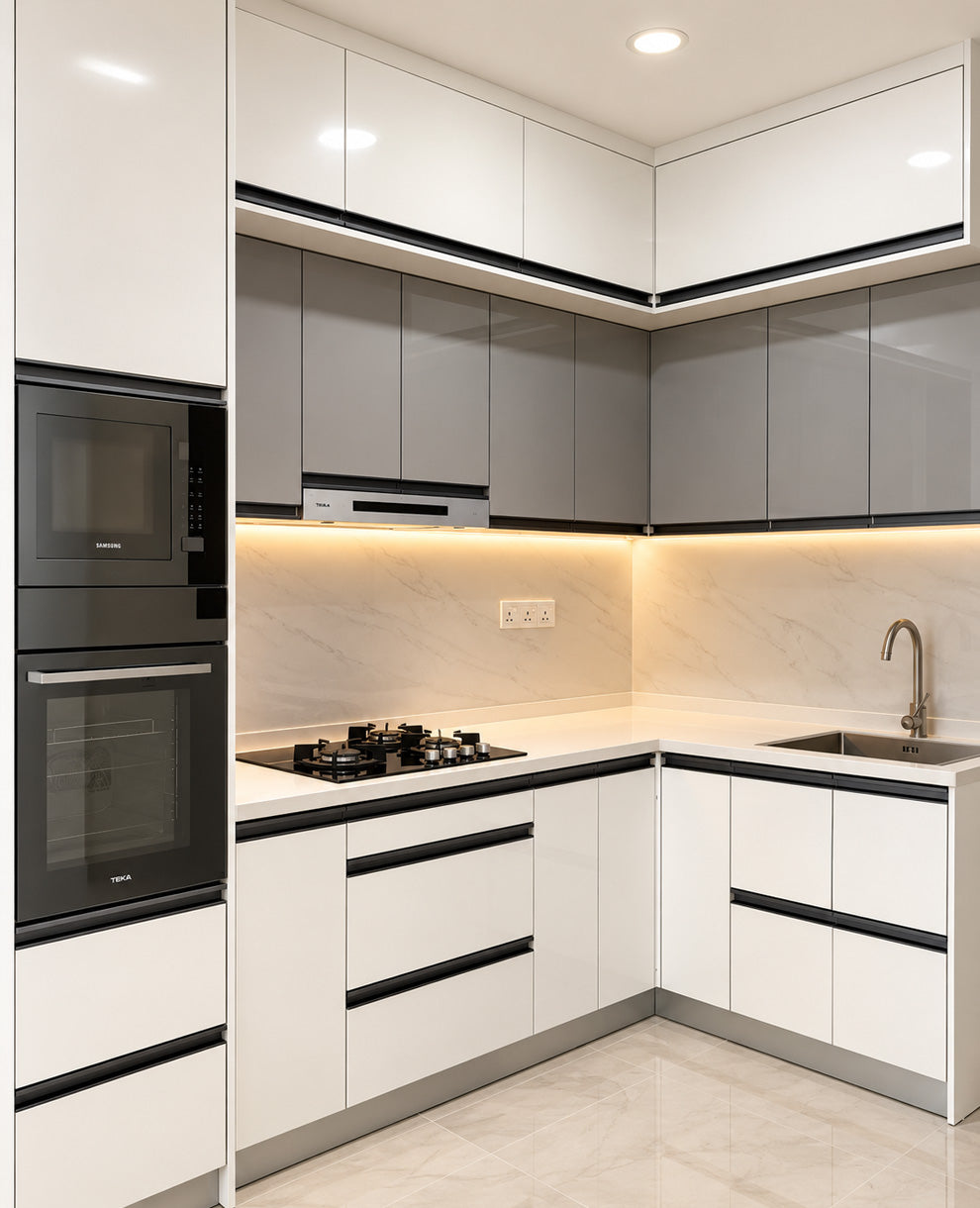 Modern L-shaped kitchen cabinets in white and gray with black handles, a built-in black oven and microwave, gas cooktop, marble backsplash, and stainless steel sink.