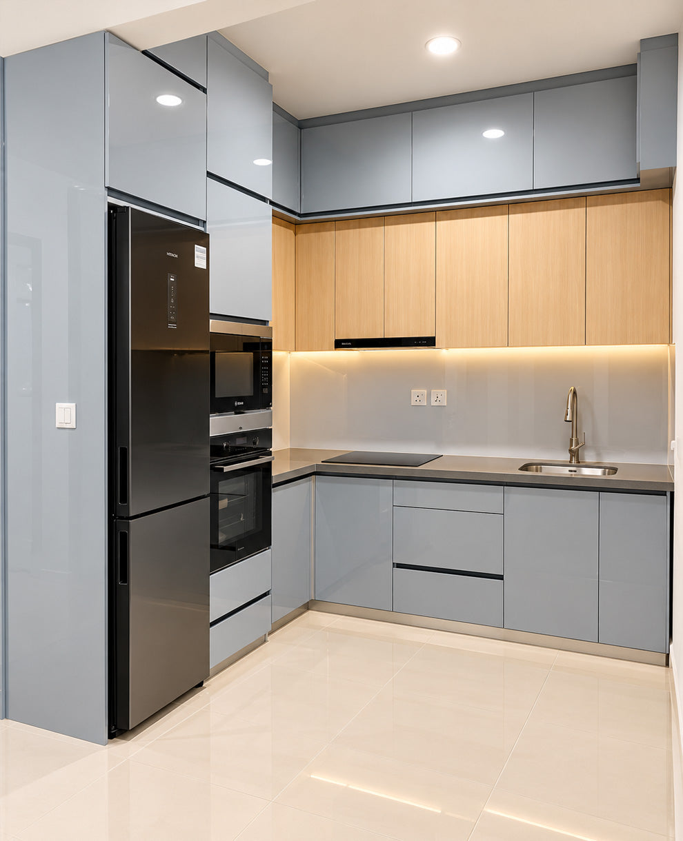 Modern kitchen interior with light gray cabinets, light wood upper cabinets, a black refrigerator, built-in appliances, a tiled backsplash, and a stainless steel sink.